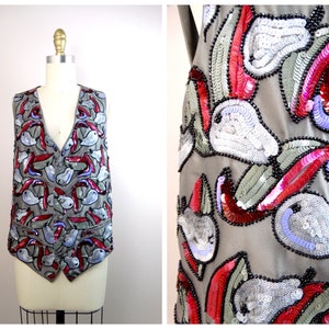 May include: A gray vest with a pattern of red, pink, and blue sequins. The sequins are shaped like peppers and pears.