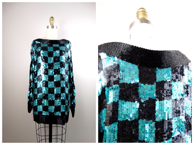 Puede incluir: Un su&eacute;ter de lentejuelas a cuadros de color azul verdoso y negro con mangas largas y cuello de barco.
