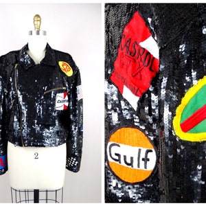 Puede incluir: Una chaqueta negra de lentejuelas con varios parches coloridos, incluyendo "Gulf", "Castrol" y "Champion".