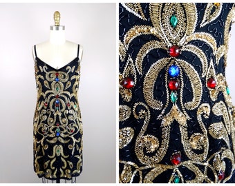 May include: A black sequined dress with gold embroidery and colorful jewels. The dress has a V-neckline and spaghetti straps.
