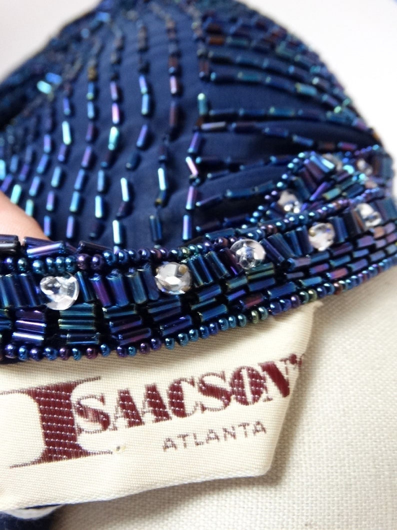 May include: A navy blue beaded top with iridescent beads and clear rhinestones. The top has a label that reads "I. Sacks, Atlanta".