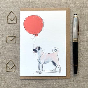May include: A white and tan dog with a red balloon. The dog is looking at the balloon and has its tongue sticking out. The balloon is tied to a string.
