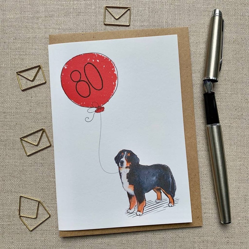 May include: A birthday card with a red balloon that says "80" and a Bernese Mountain Dog holding the string.