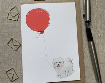 May include: A white dog with a red balloon. The dog is holding the string of the balloon in its mouth. The dog is looking to the right. The background is white.