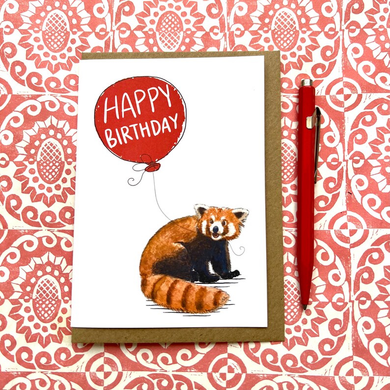 May include: A red panda holding a red balloon with the text "Happy Birthday" on it. The card is white with a brown border.