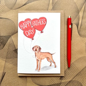 May include: A greeting card with a red heart balloon illustration that says "Happy Father's Day". A brown and white dog is holding the string of the balloons.