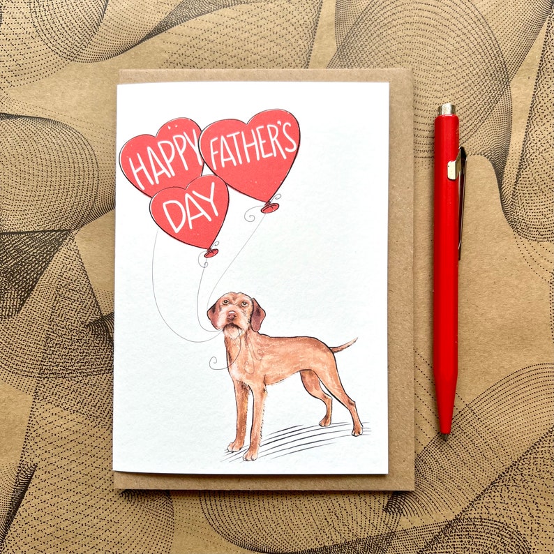 May include: A greeting card with a red heart balloon illustration that says "Happy Father's Day". A brown and white dog is holding the string of the balloons.