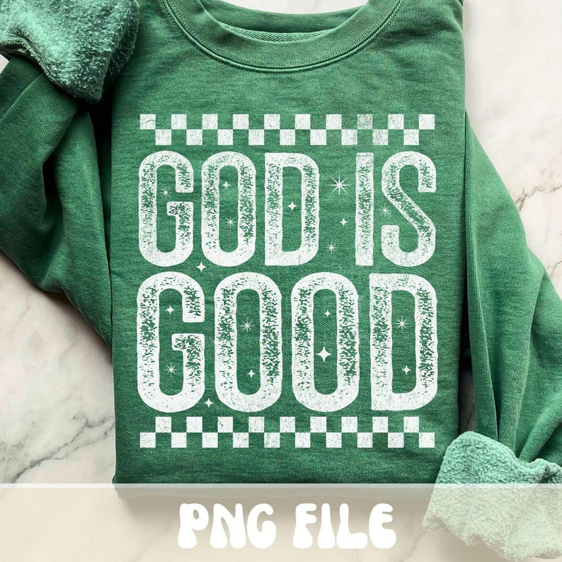 K&ouml;nnte beinhalten: Gr&uuml;nes Sweatshirt mit dem Text "GOD IS GOOD" in verblichener wei&szlig;er Schrift. Das Design beinhaltet ein Schachbrettmuster &uuml;ber und unter dem Text. Die W&ouml;rter sind leicht strukturiert mit Sternakzenten.