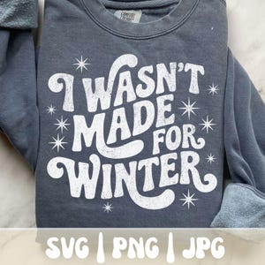 May include: A dark gray sweatshirt with the text "I WASN'T MADE FOR WINTER" in white, along with snowflake graphics. The sweatshirt has a crew neck and long sleeves. The bottom of the image shows the text "SVG | PNG | JPG".