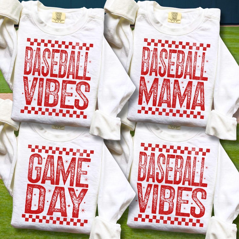 K&ouml;nnte beinhalten: Vier wei&szlig;e Langarmshirts mit rotem Text und einem karierten Rand. Die Shirts tragen die Aufschrift "Baseball Vibes", "Baseball Mama", "Game Day" und "Baseball Vibes". Die Shirts sind gefaltet und &uuml;bereinander gestapelt.