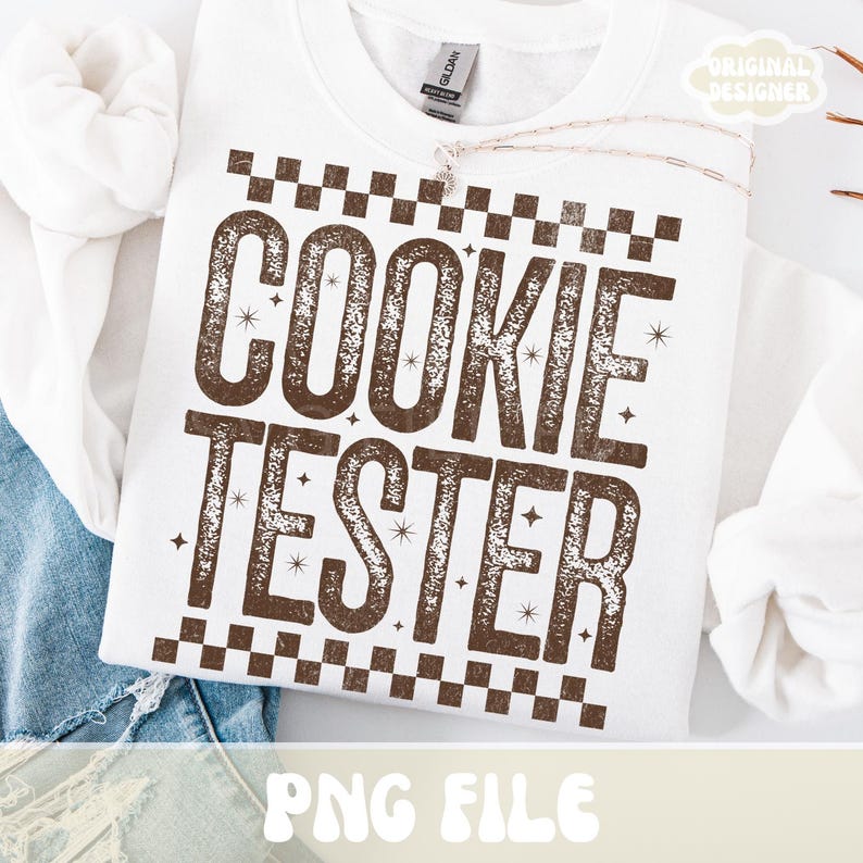 May include: White sweatshirt with the text "COOKIE TESTER" in brown, with a checkered pattern above and below the text. The words are in a bold, distressed font, with small star accents. The phrase "PNG FILE" is at the bottom.