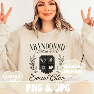Może przedstawiać: Biała bluza z czarnym nadrukiem graficznym, na kt&oacute;rym widnieje napis "Abandoned Hunting Wives Social Club" wraz z herbem o tematyce myśliwskiej. Pod herbem znajduje się tekst "Hello Hunting Season, Goodbye Husband". Tekst "SVG File Fun" znajduje się w kształcie serca w lewym dolnym rogu. Tekst "Original Designer" znajduje się w dymku w prawym g&oacute;rnym rogu. Tekst "PNG & JPG" znajduje się w dużej, kolorowej czcionce na dole obrazu.