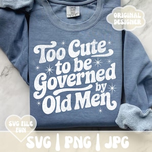 May include: A blue sweatshirt featuring the white text "Too Cute to be Governed by Old Men". The design includes star accents. The sweatshirt has a crew neck and long sleeves. The words "SVG FILE FUN" and "ORIGINAL DESIGNER" are also visible.