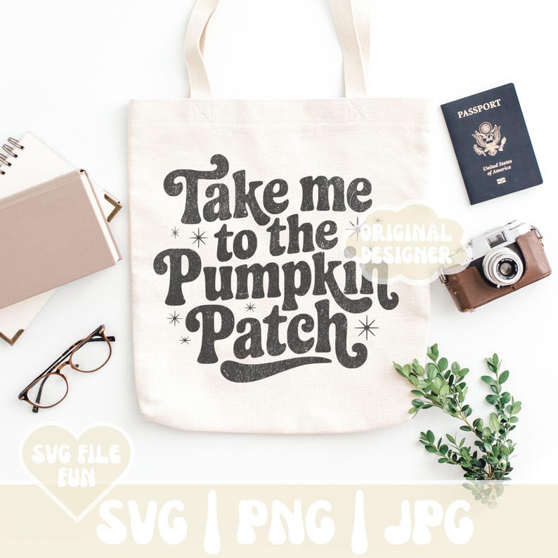 May include: Cream-colored tote bag with the text "Take me to the Pumpkin Patch" in a retro font. The image includes a passport, camera, glasses, and other accessories, suggesting a fall theme.