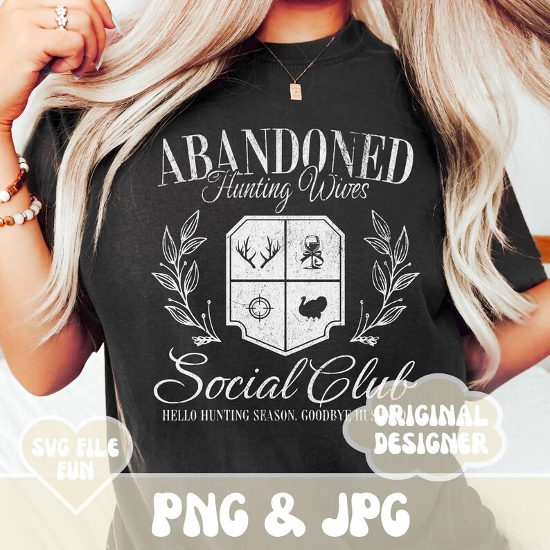 Może przedstawiać: Czarny T-shirt z białym, postarzanym wzorem graficznym, na kt&oacute;rym widnieje napis "Abandoned Hunting Wives Social Club" wraz z herbem przedstawiającym jelenia, kieliszek wina, celownik i indyka. Tekst pod herbem brzmi "Hello Hunting Season, Goodbye Husbands".