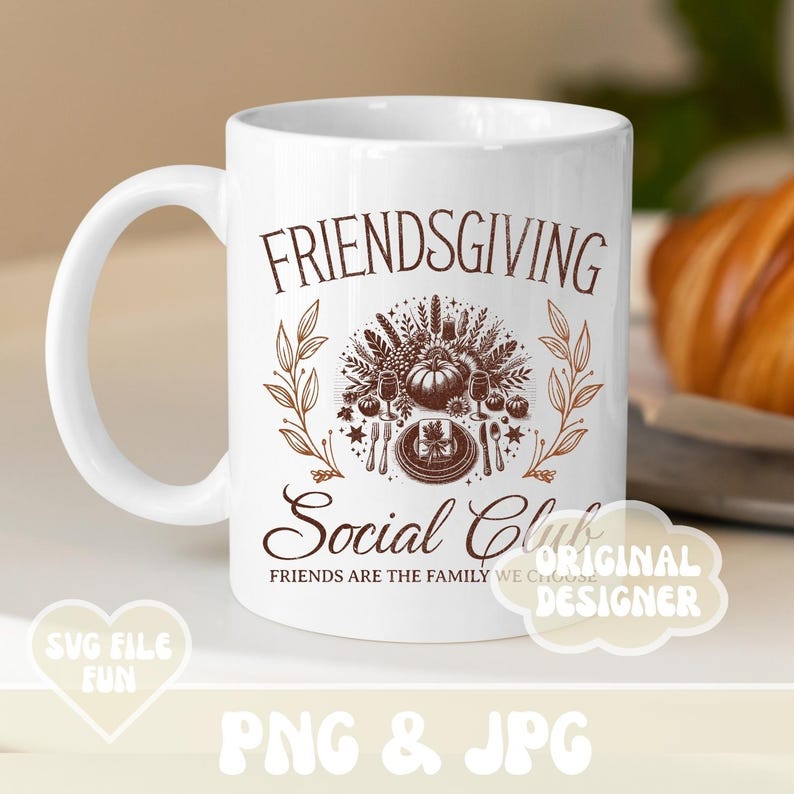 May include: White Friendsgiving Social Club mug with a brown graphic. The graphic includes the words "FRIENDSGIVING" and "Social Club", along with images of a pumpkin, plates, and cutlery. The mug also has the text "FRIENDS ARE THE FAMILY WE CHOOSE".