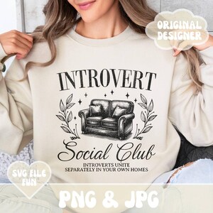 May include: A beige sweatshirt with a black graphic design that says "Introvert Social Club" with a couch and leaves. The text below the graphic says "Introverts Unite Separately in Your Own Homes".
