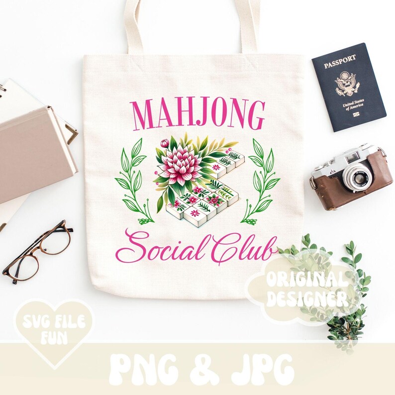 Puede incluir: Una bolsa de tela blanca con el texto "Mahjong Social Club" en letras rosas. Un dise&ntilde;o floral con flores rosas y hojas verdes rodea un juego de fichas de mahjong.