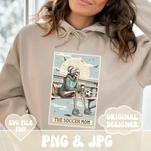 May include: A digital illustration of a skeleton wearing a blue hoodie and holding a coffee cup and soccer ball. The text "The Soccer Mom" is below the image.
