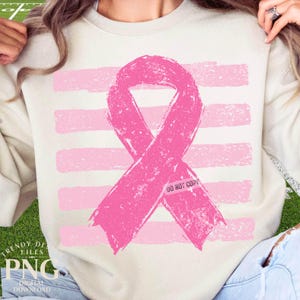 May include: A cream-colored crewneck sweatshirt featuring a large, distressed pink awareness ribbon centered over a background of horizontal, distressed pink stripes. The ribbon includes the small, faint text DO NOT COPY printed on its lower right side.