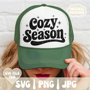Puede incluir: Gorra de camionero verde y blanca con la frase "Cozy Season" en negro. La gorra tiene una visera curva y una parte trasera de malla. El texto est&aacute; rodeado de peque&ntilde;as estrellas. La imagen tambi&eacute;n incluye el texto "SVG | PNG | JPG".