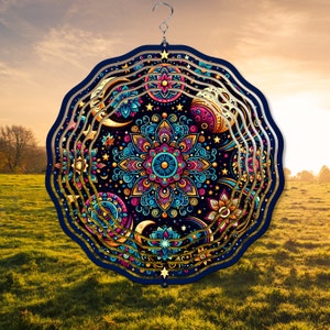 Puede incluir: Un molinillo de viento de metal colorido con un diseño de mandala. El molinillo de viento tiene múltiples capas de patrones intrincados en tonos de azul, rosa, amarillo y dorado. El diseño presenta estrellas, lunas y motivos florales.