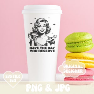 Puede incluir: Vaso de caf&eacute; de papel blanco con tapa, con una ilustraci&oacute;n retro en blanco y negro de una mujer sosteniendo una taza de t&eacute;, con el texto "HAVE THE DAY YOU DESERVE". Junto a la taza hay tres macarons coloridos.