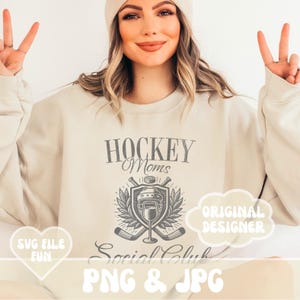 May include: A beige sweatshirt with the text "Hockey Moms Social Club" and a graphic of hockey sticks, a hockey helmet, and a wine glass. The text "Original Designer" is in a speech bubble. The text "SVG File Fun" is in a heart shape.