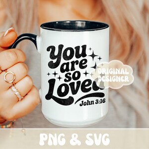Op de afbeelding: Een witte keramische mok met een zwarte handgreep en de tekst "But First, Coffee" in een vetgedrukte, zwarte letter. De mok staat tegen een vage achtergrond. De mok is ongeveer 10 cm hoog.