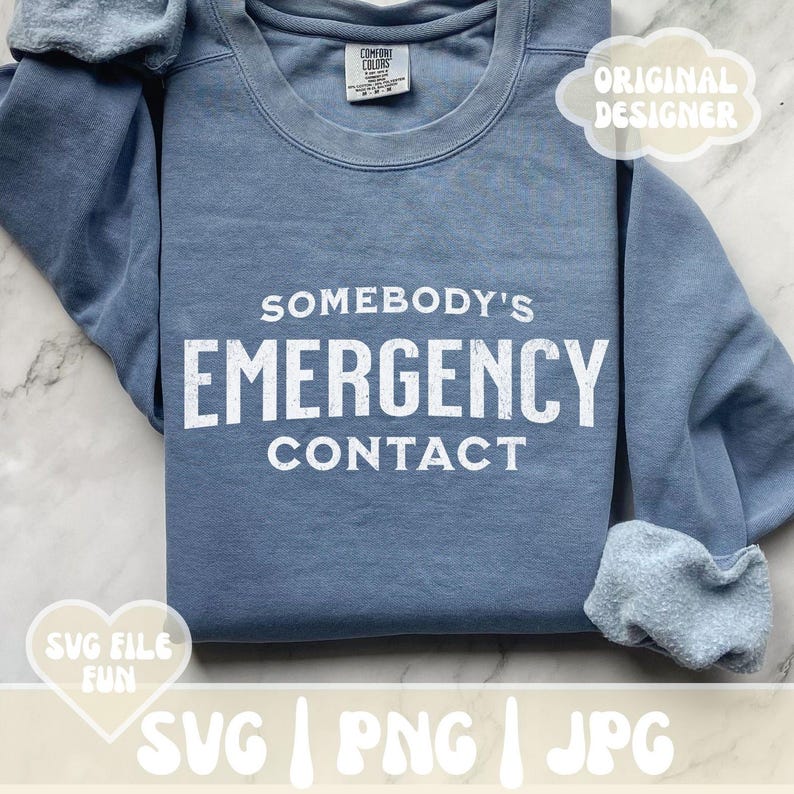以下が含まれることがあります： 白い文字で「Somebody's Emergency Contact」と書かれた青いスウェットシャツ。文字は使い古したようなヴィンテージ風です。