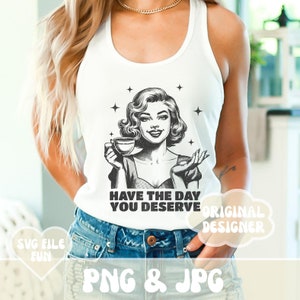 Puede incluir: Camiseta sin mangas blanca con un gr&aacute;fico en blanco y negro de una mujer sosteniendo una taza de caf&eacute;, con el texto "HAVE THE DAY YOU DESERVE". El dise&ntilde;o incluye estrellas y es de estilo retro.