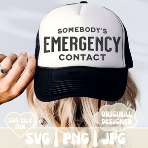 以下が含まれることがあります： 黒のメッシュバックが付いた白いトラッカーハット。ハットには「Somebody's Emergency Contact」という黒いテキストが書かれています。