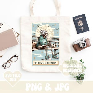 May include: A tote bag with a design of a skeleton wearing a blue shirt and holding a coffee cup. The text "The Soccer Mom" is printed on the bag.