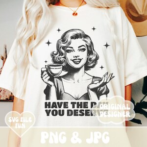 Puede incluir: Camiseta color crema con una ilustraci&oacute;n de estilo retro en blanco y negro de una mujer sosteniendo una taza de caf&eacute;. El texto "HAVE THE DAY YOU DESERVE" est&aacute; impreso debajo. La parte inferior de la camiseta tiene el texto "PNG & JPG."