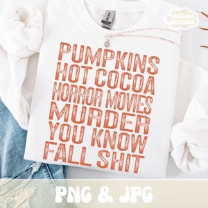 Puede incluir: Sudadera blanca con texto naranja: "PUMPKINS HOT COCOA HORROR MOVIES MURDER YOU KNOW FALL SHIT." La sudadera tiene cuello redondo y mangas largas. Las palabras "PNG & JPG" est&aacute;n en la parte inferior.
