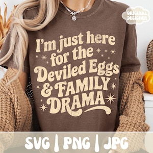 Puede incluir: Una camiseta marr&oacute;n con el texto "I'm just here for the Deviled Eggs & FAMILY DRAMA" en una fuente retro. La camiseta tambi&eacute;n tiene las palabras "SVG | PNG | JPG" en la parte inferior y "ORIGINAL DESIGNER" en la esquina superior derecha.
