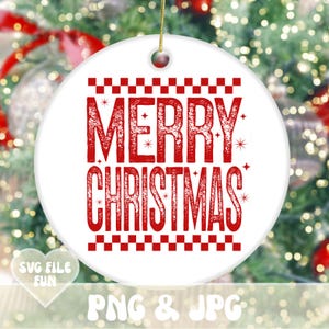 May include: Round white ceramic Christmas ornament with the words "MERRY CHRISTMAS" in red, with a decorative border. It has a gold string for hanging. The background is a blurred Christmas tree.
