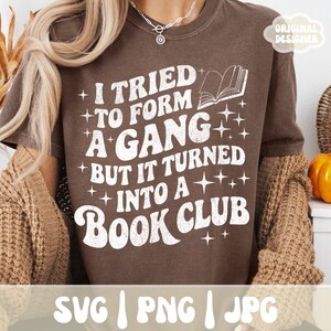 May include: A brown t-shirt with the text "I TRIED TO FORM A GANG BUT IT TURNED INTO A BOOK CLUB" in white, along with a book graphic. The shirt also has the text "SVG | PNG | JPG" at the bottom.