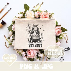 Puede incluir: Una bolsa de maquillaje de lona blanca con una ilustraci&oacute;n en blanco y negro de una mujer sosteniendo un cuchillo. El texto "Never let anyone dull your sparkle" est&aacute; impreso en la bolsa.