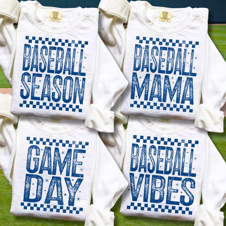 K&ouml;nnte beinhalten: Vier wei&szlig;e Langarmshirts mit blauem Text und karierten R&auml;ndern. Die Shirts zeigen die S&auml;tze "BASEBALL SEASON", "BASEBALL MAMA", "GAME DAY" und "BASEBALL VIBES". Die Shirts sind gefaltet und auf einer gr&uuml;nen Oberfl&auml;che angeordnet.
