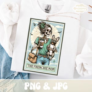 May include: White sweatshirt featuring a graphic of a skeleton holding a coffee cup and a French Bulldog. The graphic is in a rectangular frame with the text "THE FRENCHIE MOM". The design includes bats, stars, and a sunburst background.