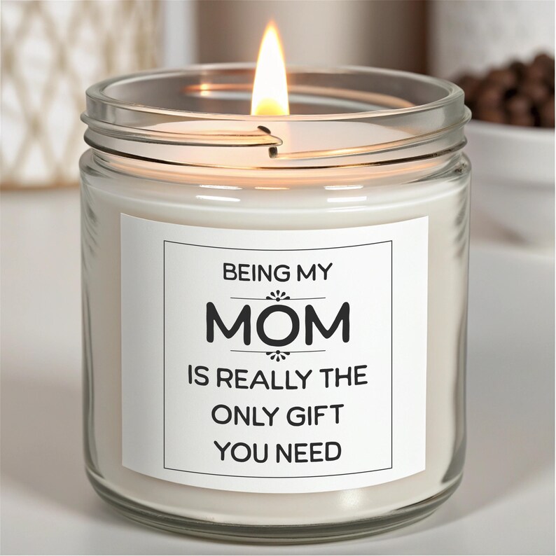May include: A white candle in a clear glass jar with a white label that reads "Being my Mom is really the only gift you need".