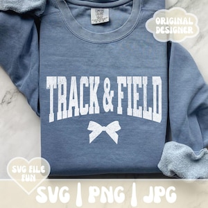 May include: A blue sweatshirt with the text "TRACK & FIELD" in white with a white bow underneath. The text has a distressed look. The sweatshirt is folded in half and the text "SVG FILE FUN" is visible in the lower left corner. The text "SVG | PNG | JPG" is visible in the lower right corner.
