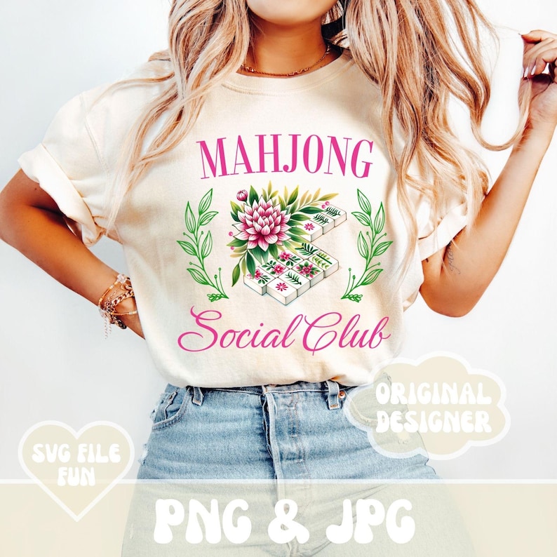 Puede incluir: Una camiseta blanca con el texto "Mahjong Social Club" en letras rosas. Un dise&ntilde;o floral con flores rosas y hojas verdes rodea una pila de fichas de mahjong.
