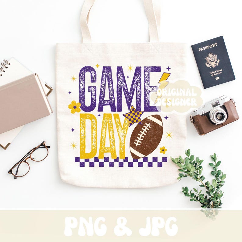 Puede incluir: Una bolsa de lona blanca con las palabras "GAME DAY" en morado y amarillo, junto con un gr&aacute;fico de f&uacute;tbol americano. La bolsa est&aacute; rodeada por un pasaporte, una c&aacute;mara vintage y otros accesorios.