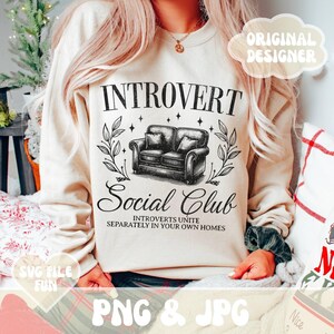 May include: A beige sweatshirt with the text "INTROVERT Social Club" and a black and white illustration of a couch. The text below the couch reads "INTROVERTS UNITE SEPARATELY IN YOUR OWN HOMES".
