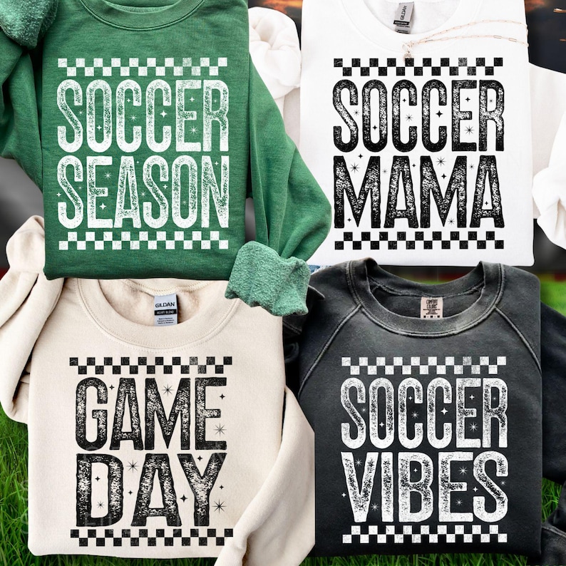 K&ouml;nnte beinhalten: Vier Sweatshirts mit Fu&szlig;ball-Text. Die Sweatshirts sind in Gr&uuml;n, Wei&szlig;, Creme und Anthrazitgrau gehalten. Die Texte lauten "SOCCER SEASON", "SOCCER MAMA", "GAME DAY" und "SOCCER VIBES". Jedes Design hat einen karierten Rand.
