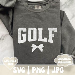 May include: Gray sweatshirt with the word "GOLF" in white text and a white bow. The sweatshirt is a comfortable, casual style.