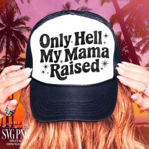 Könnte beinhalten: Schwarz-weiße Trucker-Cap mit dem Text "Only Hell My Mama Raised". Die Cap hat eine weiße Front und eine schwarze Mesh-Rückseite. Der Text ist fett gedruckt und mit Sternen verziert. Ein lustiges, lässiges Accessoire.