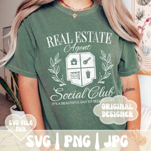 Może przedstawiać: Zielony T-shirt z białym nadrukiem, na kt&oacute;rym widnieje napis "Real Estate Agent Social Club It's a beautiful day to sell houses". Grafika zawiera dom, klucz, znak "Sprzedane" i kubek kawy.